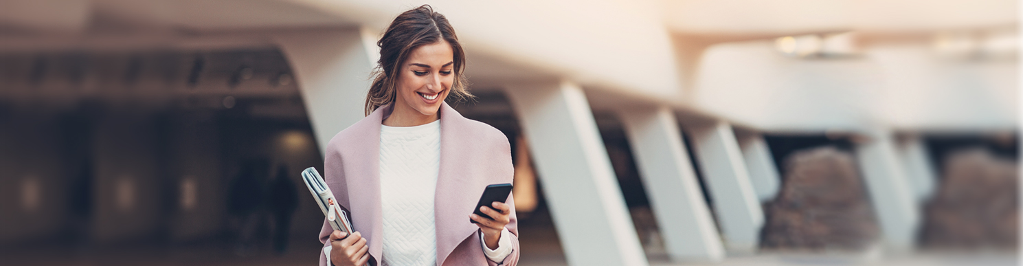 Woman in pink coat looking at her phone